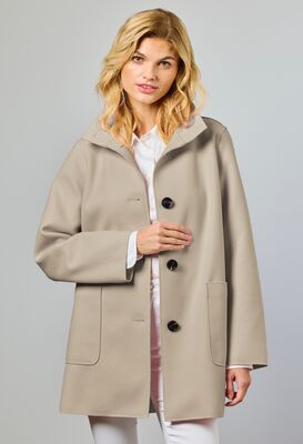 Junge beigensävyinen naisellinen kevättakki